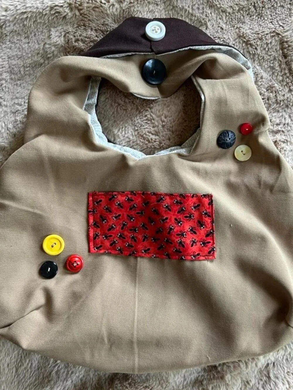 Brown & tan hobo bag with red ant pattern front pocket and hand sewn buttons